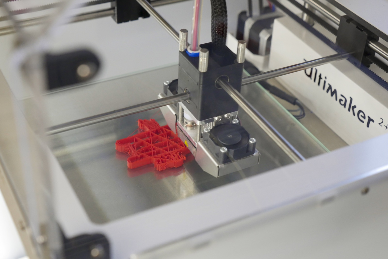 A 3D printer produces a red workpiece